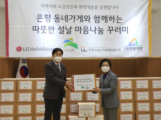 윤용 LG헬로비전 CRO 전무(왼쪽)와 김미경 은평구청장(오른쪽)이 '마음나눔 꾸러미'를 들어 보이고 있다. 꾸러미는 신응암시장 소상공인들이 판매하는 물품으로 채워졌다. LG헬로비전 제공